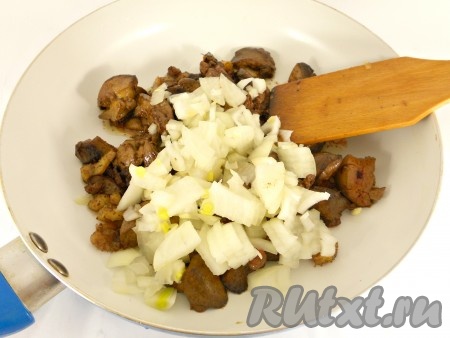 Добавить к печени мелко порезанный репчатый лук, обжаривать его вместе с печенью на сильном огне 3 минуты. Затем огонь убавить и жарить еще 5 минут, постоянно помешивая.