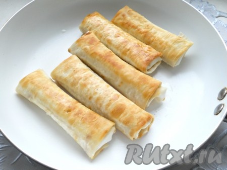 Далее обжарить подготовленные трубочки из лаваша с сыром на разогретой с растительным маслом сковороде на огне ниже среднего с двух сторон до румяной корочки (по 2-4 минуты с каждой стороны).