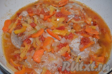 Накрыть сковороду крышкой, дать воде закипеть, а затем на минимальном огне тушить курицу с овощами 15-20 минут, несколько раз за это время можно перемешать. В конце приготовления добавить измельчённый чеснок.