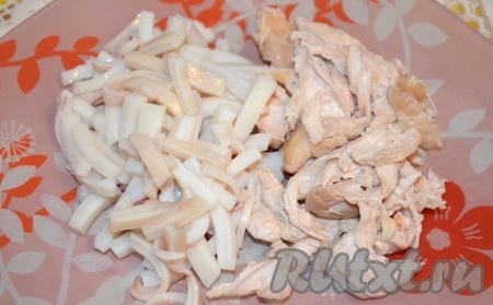 Кальмаров полностью разморозить, очистить от плёночки, покрывающих их снаружи, удалить хорду, находящуюся внутри тушки. В кастрюлю с кипящей водой выложить кальмаров, дать воде снова закипеть, после этого варить кальмаров на среднем огне 30 секунд. Сразу достать кальмаров из кастрюли, дать остыть. Заранее отварить куриное филе в течение 25 минут с момента закипания подсоленной воды. Варёное куриное мясо полностью остудить. Кальмаров нарезать мелкой соломкой. Куриное филе разобрать на волокна.