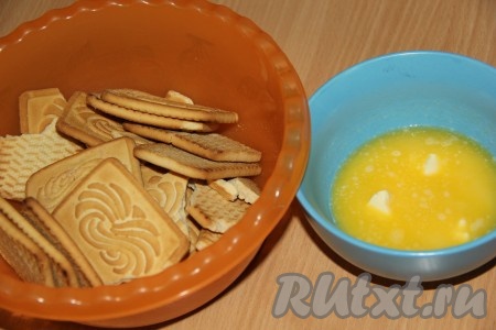 Печенье измельчить в блендере или выложить в пакет и прокатать скалкой до мелкой крошки. Сливочное масло растопить, слегка остудить и добавить к измельчённому печенью.
