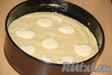 Форму для выпекания (я использовала разъёмную диаметром 22 см) смазать растительным маслом. Вылить тесто в форму и разровнять. Сверху на тесто выложить 1/2 творожной начинки в виде островков.
