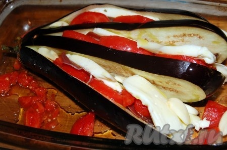 Баклажан помыть, срезать хвостик. Разрезать баклажан вдоль на полоски толщиной около 1 сантиметра, но не дорезая до конца, а как бы веером. Аккуратно посолить веер из баклажана. Между полосками баклажана выложить ломтики сыра, кусочки помидора и пластинки чеснока. Получится аппетитный веер из баклажана с помидорами и сыром. Оставшиеся помидоры нарезать, выложить в форму для запекания. На помидоры выложить веер из баклажана.