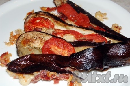 Веер из баклажана, запечённый с помидорами и сыром, достать из духовки, переложить на блюдо и в горячем виде подать к столу.