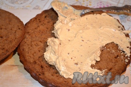 Промазать нижний корж половиной крема.