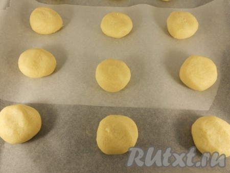 Противень застелить пергаментной бумагой. Из теста скатать небольшие шарики и выложить их на противень на расстоянии около 10 см (печенье в процессе выпечки будет растекаться).