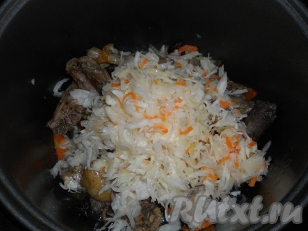 Добавить квашеную капусту в чашу мультиварки к утке, овощам и сухофруктам.
