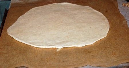 Каждый шар на присыпанной мукой поверхности раскатать в тонкий пласт и выложить на противень, застеленный бумагой для выпечки.