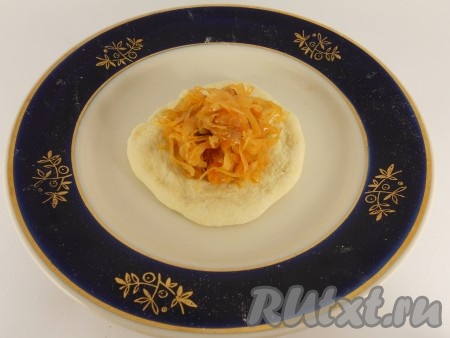 Далее каждый шарик приплюснуть и растянуть немного руками. В центр лепешки поместить по 1-2 чайной ложки капусты.