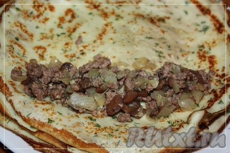 У меня в пироге начинки из мяса и грибов много, я клала по 2 столовые ложки начинки на блин, можно и по 1 столовой ложке класть, тогда будет более рельефный пирог. Начинку выложить на край блина и свернуть рулетом.