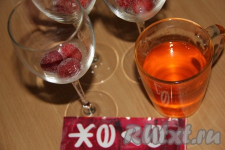 Если вы будете готовить с замороженными ягодами, тогда их нужно разморозить, а лишнюю жидкость слить. В чашке в 200 миллилитрах горячей воды развести желе (у меня - с апельсиновым вкусом) и тщательно перемешать. На дно фужеров выложить ягоды.