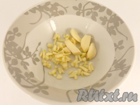 Чеснок очистить, 2 зубчика порезать мелкими кусочками, 2 зубчика - разрезать пополам.

