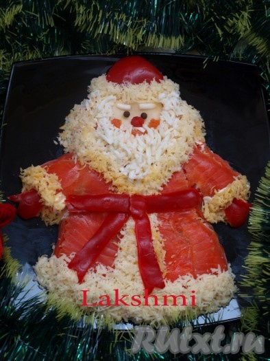 Оформляем салат "Дед Мороз" так: лицо - сыр чеддер; глаза - горошины чёрного перца; нос - из моркови, окрашенной свекольным соком; щёки, рот - кусочки красной рыбы. Усы, борода, брови - яичный белок. Окантовка "шубы" из твёрдого сыра; пояс, шапка и рукавицы - из перца.