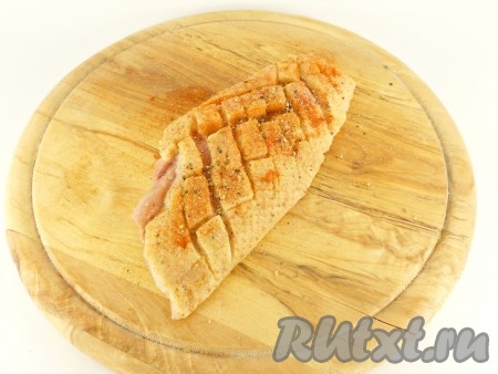 Посолить, посыпать паприкой и свежемолотым перцем, втирая специи в разрезы.