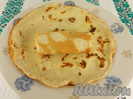 Свернуть блинчик конвертиком, загибая края, чтобы начинка не вытекла.
