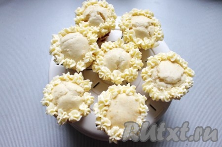 Маффины украсить кремом с помощью кондитерского мешка с зубчатой насадкой.