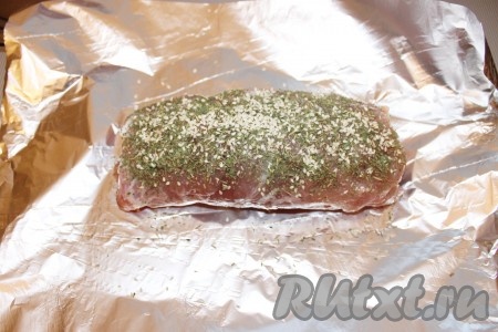 Мясной рулет положить на середину фольги, сверху густо посыпать петрушкой, розмарином, солью, перцем и кунжутом.
