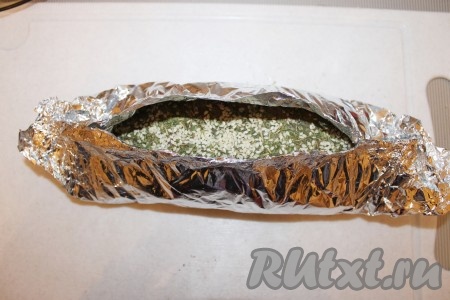 Плотно завернуть с торцов, оставляя верх открытым - таким образом сформировав "лодочку".&nbsp;Рулет уложить на противень с водой и поставить в заранее разогретую до 200-220 градусов духовку. Запекать 1 час. За 20 минут до готовности рулет полить смесью оливкового масла и мелко натертого чеснока.
