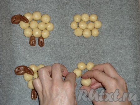 Противень застелить пергаментом и начать формировать печенье "Барашки". Из охлаждённого белого теста скатать небольшие шарики и сформировать туловище, а из шоколадного - голову, ухо и копыта. С помощью зубочистки обозначить &nbsp;глазки, рот и сделать разрез на копытах.
