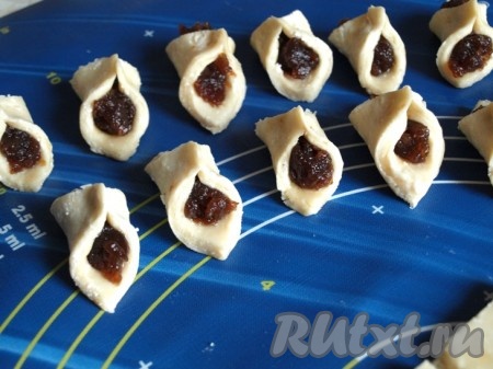 В центр каждого квадрата кладём по одной чайной ложечке густого джема и склеиваем творожное печенье наискосок.