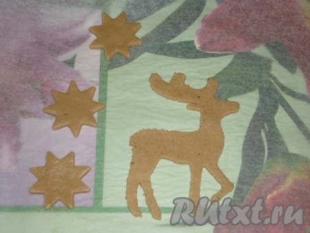 Раскатать тесто на пергаменте, чтобы при переносе детали не деформировались. Вырезать детали  с помощью заранее приготовленных трафаретов. Также можно использовать формы для печенья. 