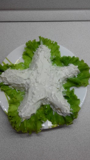 Первым слоем выкладываем рис и покрываем его салатной заправкой.