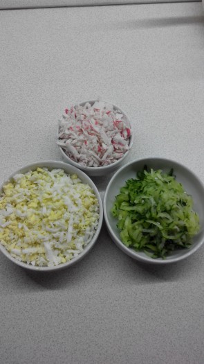 В кипящую воду добавляем соль, лавровый лист, несколько ложек лимонного сока. Бросаем креветки и варим в течение 3 минут с момента закипания. Огурчик, яйца и крабовые палочки трем на крупной терке.