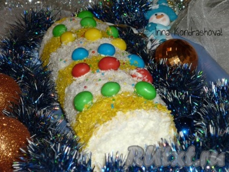 Перед подачей можно украсить рулет. Я украсила в виде хлопушки с помощью разноцветной кокосовой стружки и конфет M&M'S. Вкусный, нежный рулет из бисквита с творожно-масляным кремом готов.