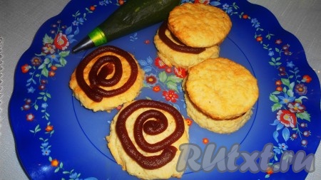 Собираем каждое пирожное, пользуясь кондитерским мешком. На одно печенье наносим повидло и накрываем вторым печеньем.
