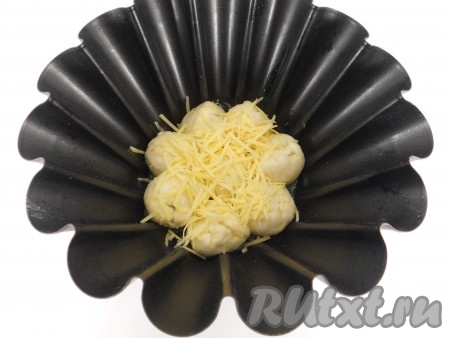 Выкладывать шарики из теста слоями в форму для выпечки диаметром 19-20 сантиметров. Каждый слой посыпать натёртым сыром.