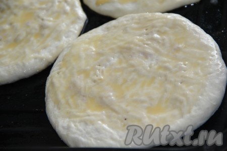 Переложить лепёшки с начинкой на противень, смазанный растительным маслом. Верх лепёшек смазать взбитым яйцом. Сделать несколько наколов вилкой. Поставить противень с лепёшками в разогретую духовку и выпекать при 180 градусах до золотистого цвета, примерно 10-15 минут.

