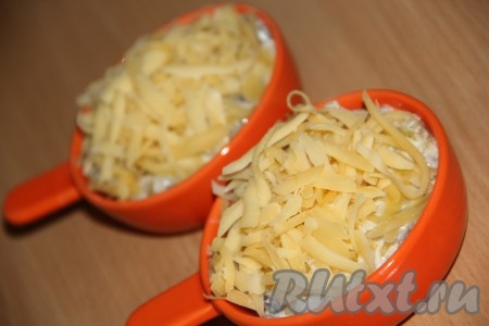 Разложить шампиньоны, тушёные в сметане, по небольшом формам для запекания (кокотницам), присыпать обильно сыром, поставить в разогретую духовку и запекать грибной жульен 10-15 минут при температуре 180 градусов.