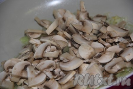 К обжаренному луку добавить шампиньоны, перемешать и обжаривать их минут 10, периодически помешивая.
