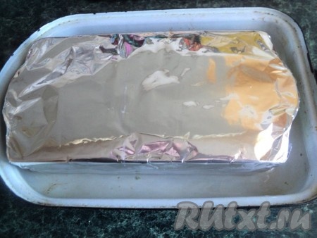 Накрыть форму с рыбным террином фольгой и поставить в форму большего размера, в которую на 1/2 высоты налить воды. Запекать в разогретой духовке при температуре 180 градусов 1 час 15 минут. Готовый террин, не вынимая из формы, охладить до комнатной температуры и поставить в холодильник на ночь. Сверху можно положить небольшой груз.
