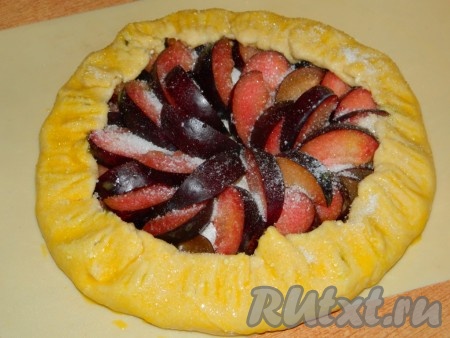 3-4 сливы нарезаем на дольки и выкладываем в центр круга - там где присыпали крахмалом. Затем края заворачиваем на начинку, формируя галету. Смазываем взбитым желтком пирог и присыпаем его сверху сахаром. Выпекаем творожную галету со сливами в разогретой духовке при температуре 200 градусов минут 30.