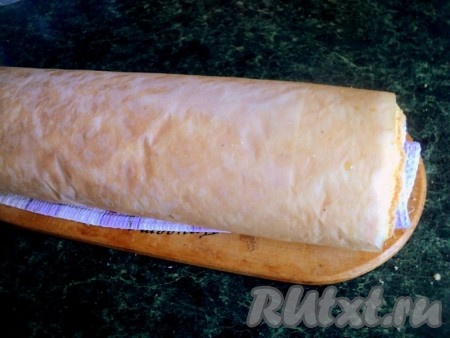 Выпекать при температуре 180 градусов 15-20 минут до легкого зарумянивания. Готовый бисквит накрыть полотенцем и, не снимая бумагу для выпечки, свернуть рулетом. Охладить.
