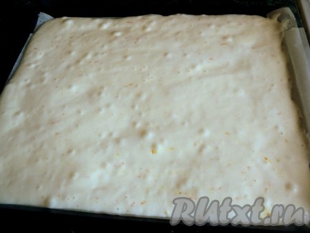 Смешать просеянную муку с крахмалом, разрыхлителем и цедрой апельсина и, в несколько приемов, добавить к яичной смеси. Размешивать ложкой снизу вверх, методом складывания. Противень застелить бумагой для выпечки, смазать маслом, вылить тесто и равномерно распределить его.
