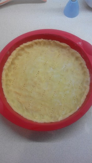 Тесто раскатать в пласт и выстелить им форму для выпечки. Наколоть тесто вилкой и охладить 15 минут. Затем выпекать основу пирога в разогретой духовке 10 минут при температуре 200 градусов. После этого снизить температуру до 190 градусов и выпекать еще 5 минут.