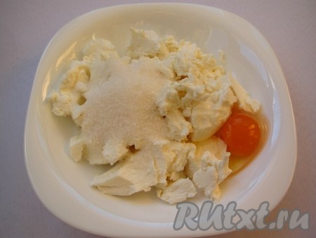 Приготовьте творожную начинку, для этого в творог добавьте куриное яйцо и сахар, разотрите вилкой в однородную массу.