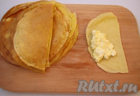 Каждый блин разрежьте пополам и выложите начинку.