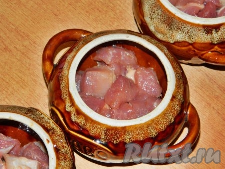 В горшочки выложить мясо.