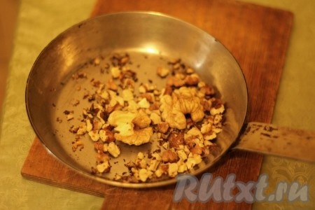 Орехи, если будете использовать, нужно порубить ножом на более мелкие кусочки и обжарить, постоянно помешивая, в течение 3 минут на сухой сковородке.