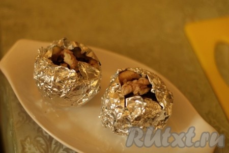 Наколоть каждое яблоко зубочисткой в нескольких местах и завернуть в фольгу, оставив открытым небольшое отверстие сверху. Яблоки, завёрнутые в фольгу, поместить в форму для запекания (или на противень) и отправить в духовку, предварительно разогретую до 180 градусов, минут на 25-35. Продолжительность запекания во многом зависит от сорта яблок. В процессе запекания стенки яблок должны стать достаточно мягкими, но при этом потерять форму яблоки не должны. Для того чтобы проверить готовность, проколите яблоко зубочисткой прямо через фольгу, если зубочистка входит легко, значит яблоки готовы, доставайте их из духовки.