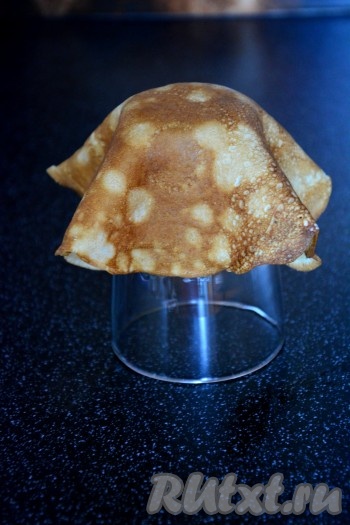 Для приготовления корзиночек из блинов нужно взять один блин и стеклянный стакан. Стакан перевернуть вверх дном, на него наложить блинчик.
