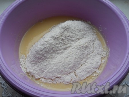 Начать частями всыпать просеянную муку, каждый раз очень хорошо вмешивая её в тесто вначале ложкой, а затем уже начать вымешивать тесто руками.