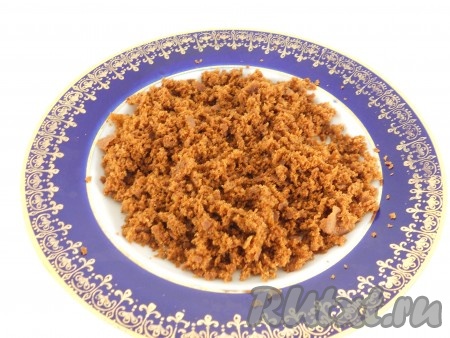 У остывшего коржа срезать тонко подпечённый низ, подсушить его немного в микроволновке (или на сухой сковороде), остудить и размять в крошку.