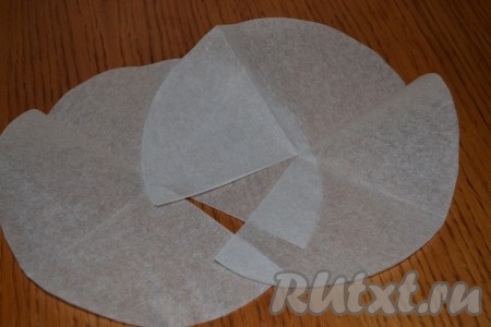 Теперь нам нужно подготовить наши формочки для выпекания в виде конусов. Для этого мы используем пергаментную бумагу – с помощью тарелки диаметром 20 см я вырезала 6 одинаковых кругов. Каждый круг разрезала до середины и свернула кулечком. Чтобы наш конус держался, необходимо края скрепить степлером.
