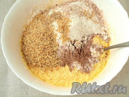 Заливаем миндаль кипятком, затем очищаем и обсушиваем. Обжариваем миндаль и грецкие орехи, помешивая, на сковороде. Затем измельчаем орешки в комбайне в крошку. Измельченные орехи, какао, ванилин, муку и разрыхлитель добавляем в сливочно-яичную массу и перемешиваем.
