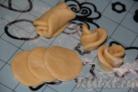 Сложить три круга из теста внахлёст, свернуть их вместе, как на фото, а затем разрезать пополам, получатся две "розочки". Аналогично сделать "розочки" из оставшегося теста.