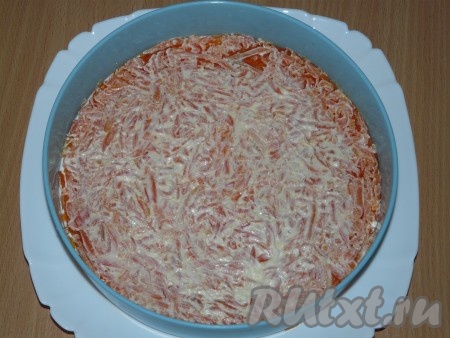 На плоскую тарелку выложить бортики для салата. У меня диаметр бортиков 25 см. Морковь натереть на крупной тёрке, выложить на дно тарелки, разровнять и смазать майонезом.